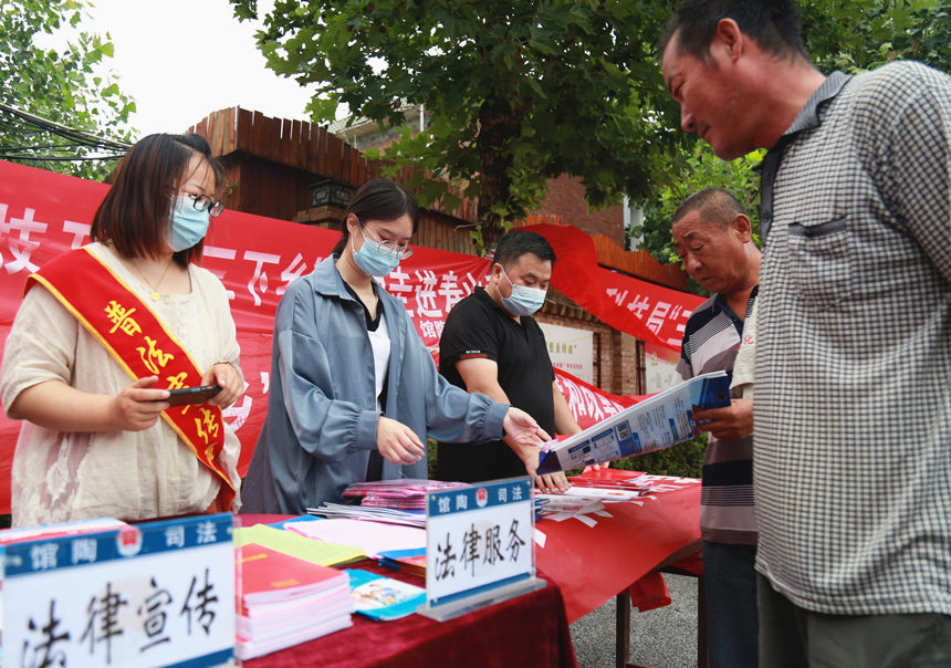 館陶縣“惠民實踐團”活動現(xiàn)場工作人員在發(fā)宣傳單。郭江鵬攝