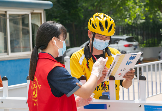 志愿者在社區(qū)門口接送快遞。石家莊市文明辦供圖