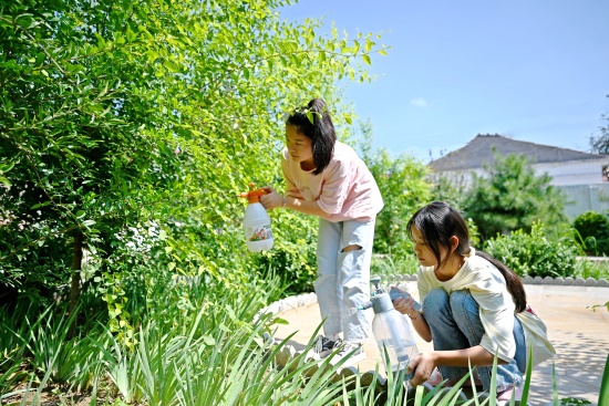 孩子們在村內(nèi)小廣場為花草澆水。 劉子袆攝