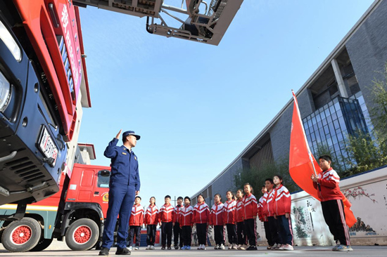 在文安縣消防救援大隊(duì)，消防隊(duì)員向孩子們介紹消防車種類。 郭小婧攝