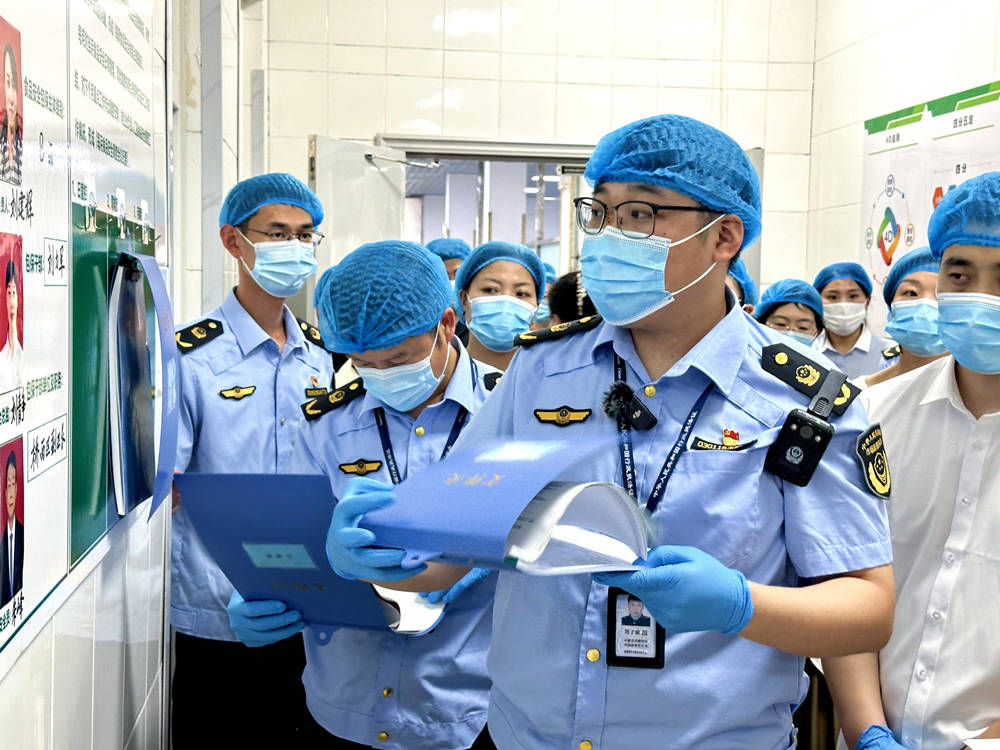 工作人員檢查學校食堂臺賬。石家莊市橋西區(qū)市場監(jiān)督管理局供圖